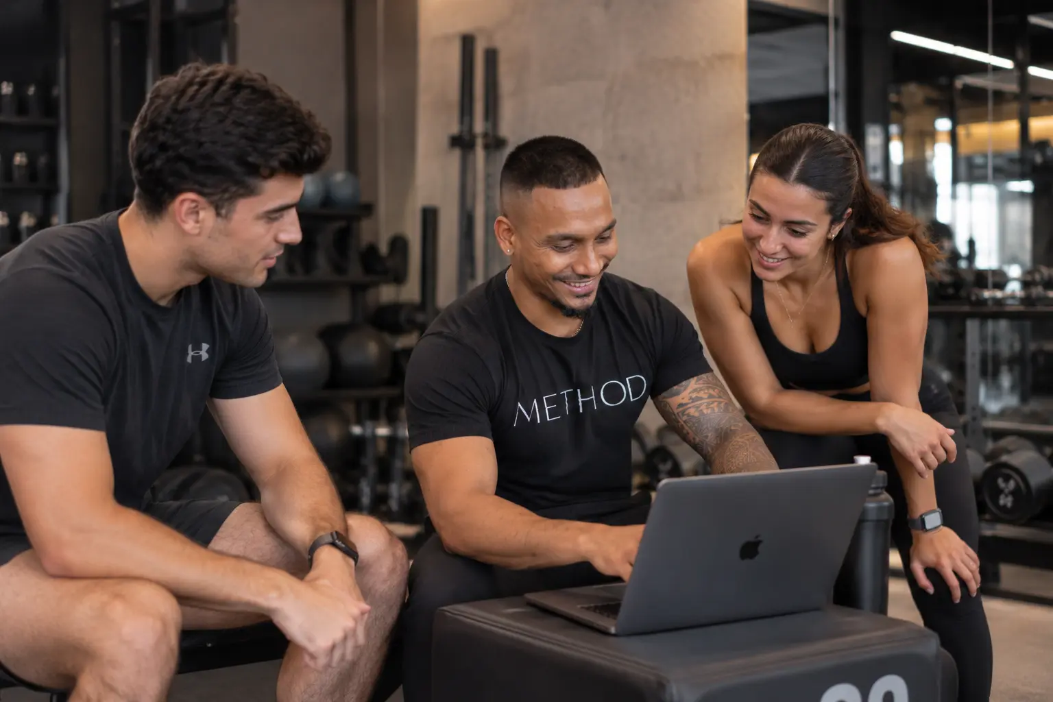 Deep reviewing a training plan with two clients in a Dubai gym